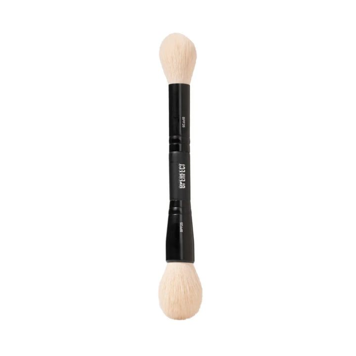 Double-ended makeup brush with black handle and cream bristles on a white background