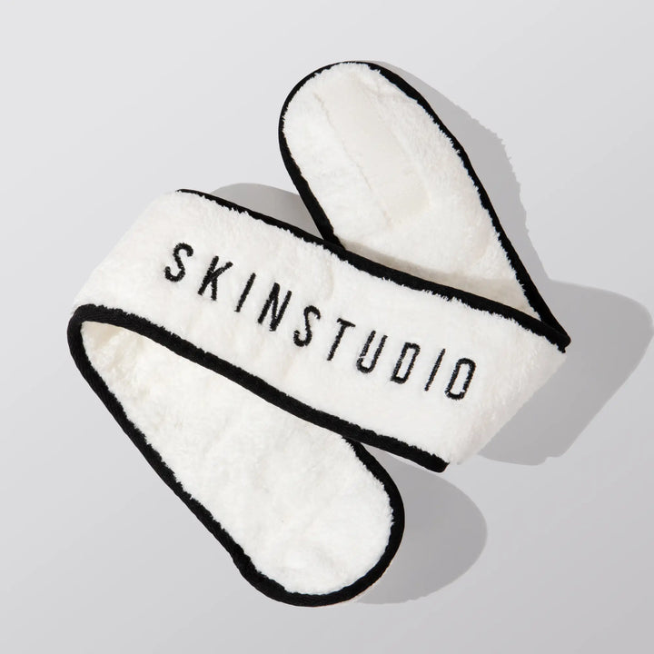 White headband with black text 'SKINSTUDIO' on a light gray background