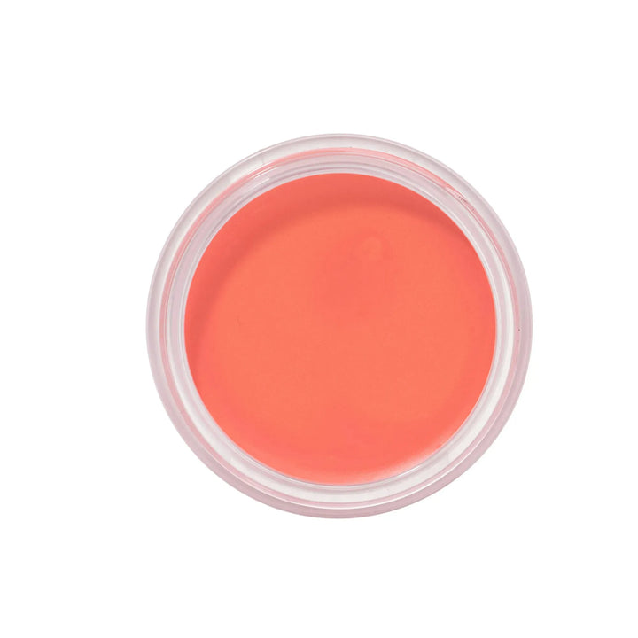Coral cream blusher in a small transparent container on a white background