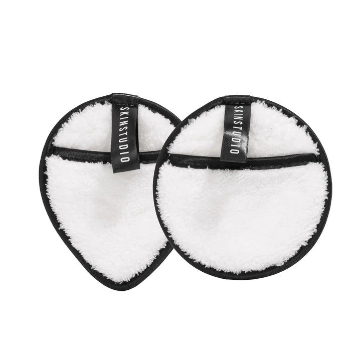 Two black and white makeup cleansing pads with a teardrop and circular shape, labelled 'SKIN STUDIO'.
