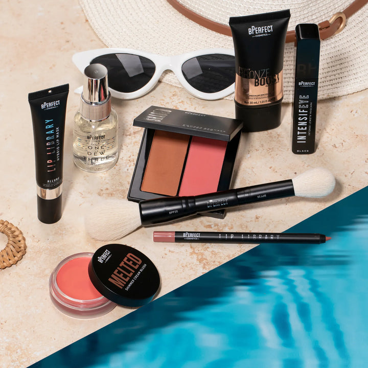 Makeup products including bronzer, blush, lip products, gel drops, mascara, setting spray, and brushes with a pool setting.